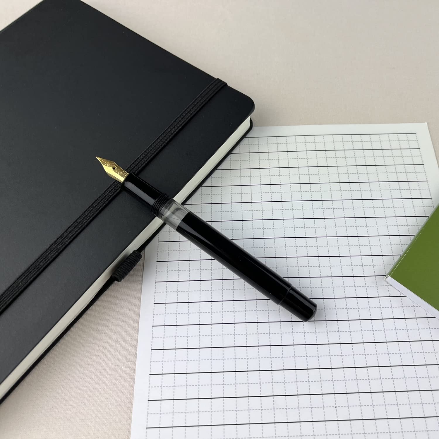 Scrikss 419 Medium Nib Fountain Pen in Black GT on a squared sheet and diary